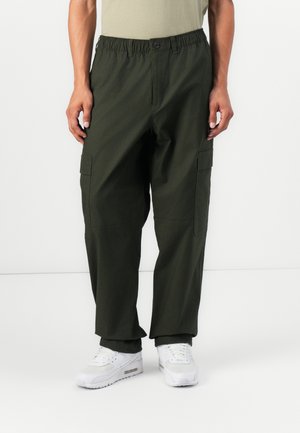 Khaki cargo pants with elastic waistband, two side pockets, and reinforced seams; made from a lightweight, textured fabric.