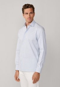 Lichtblauw en wit gestreepte button-up shirt met lange mouwen, een kraag en een rechte zoom, gemaakt van lichtgewicht stof.