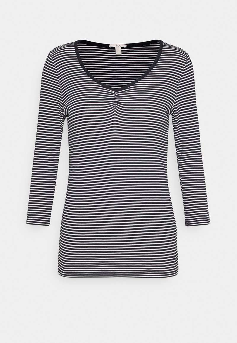 Långärmad topp med v-ringning i svart och vitt randigt mönster; har en knappdetalj vid halsen och ett mjukt, stretschigt tyg.