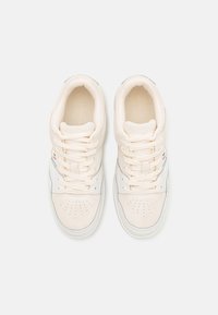 Białe trampki z mieszanką zamszu i skóry. Okrągły czubek, perforowane detale na wierzchu, płaskie sznurowadła. Subtelne akcenty kolorystyczne po bokach.