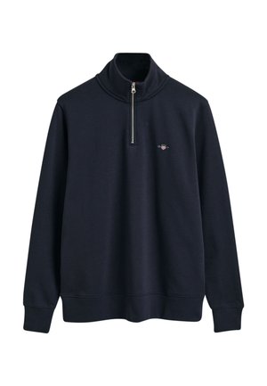 Navy blue zip neck sweatshirt made of soft fabric with long sleeves and a ribbed hem. Features a small logo on the chest.