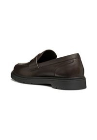 Zapatos de cuero marrón oscuro tipo slip-on con punta redonda y suela de goma negra baja. Presentan un diseño con costuras y un ligero tacón para mayor soporte.