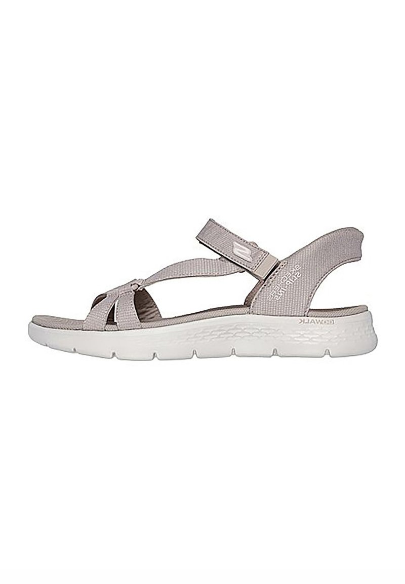 Sandalia gris claro con correas de tela y cierre de gancho y bucle. Suela acolchada con suela de goma blanca texturizada. Diseño minimalista.