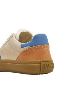 Sneaker in suede con sezioni beige, arancioni e blu; suola in gomma beige; presenta il timbro "1973" e "NATO IN PORTOGALLO" sul tallone.