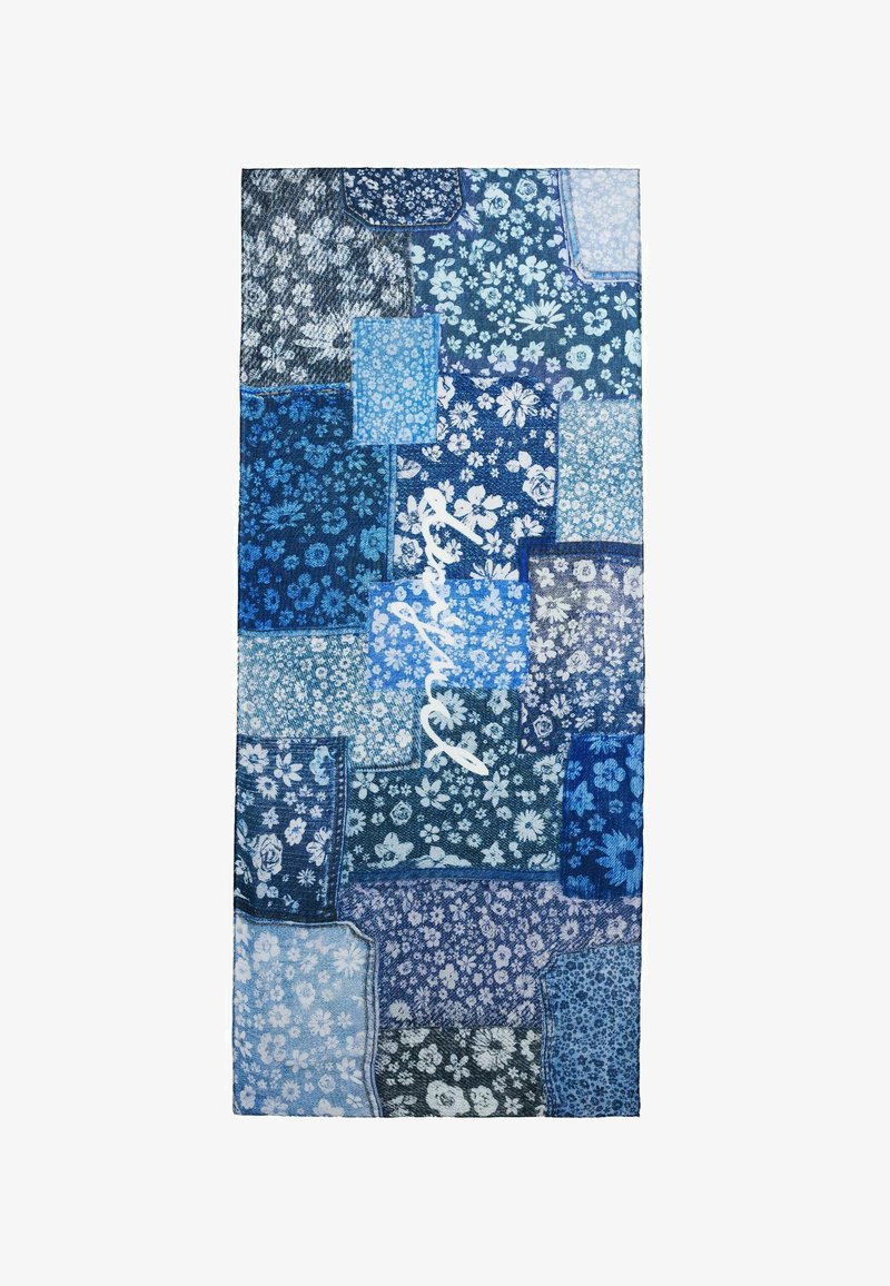 Textil azul con un diseño de patchwork que incluye patrones florales y abstractos. Presenta varios tonos de azul y un detalle en blanco con escritura.