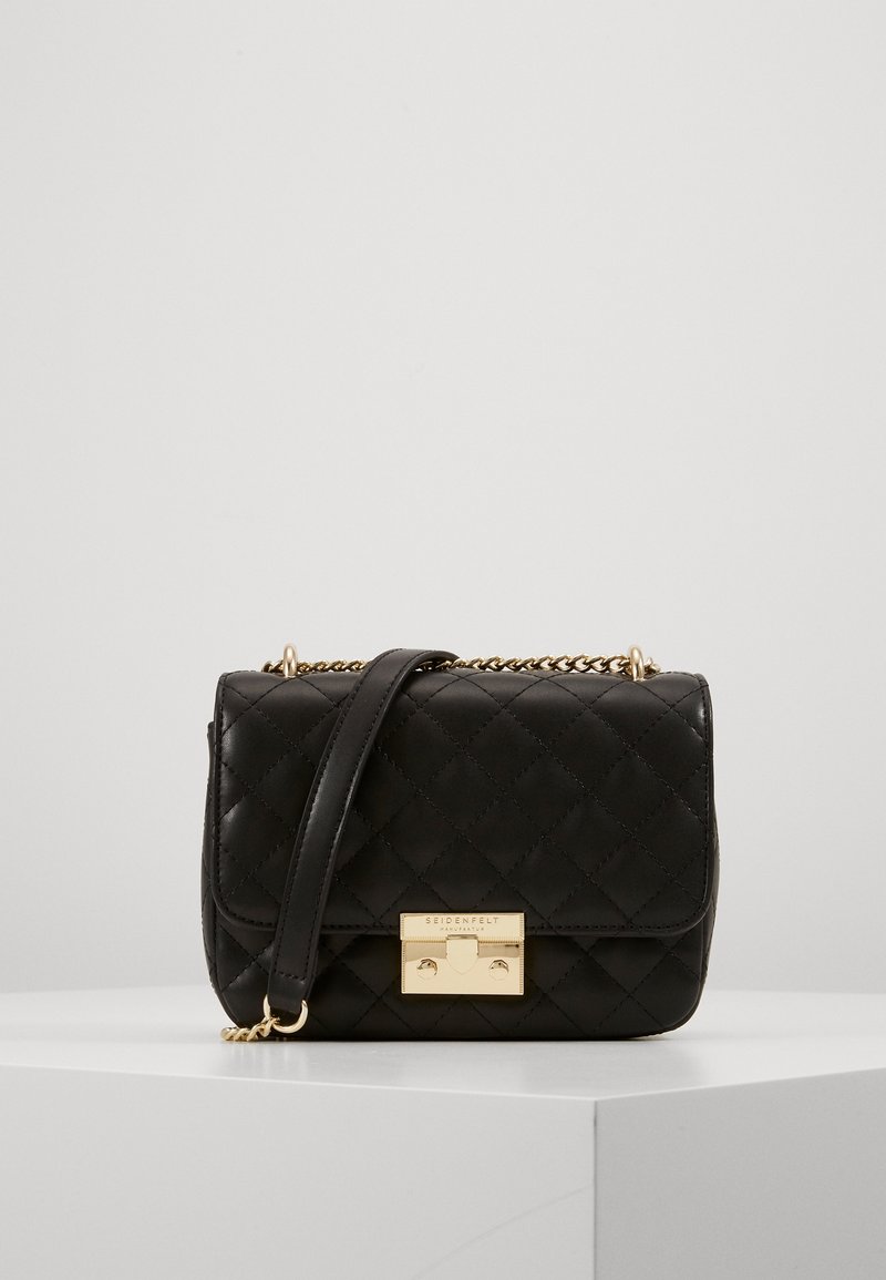 Black quilted leather handbag features a gold-tone clasp and chain strap, with a structured rectangular shape and smooth texture.