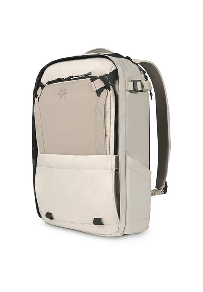 Mochila en gris claro con detalles en negro, que cuenta con un bolsillo frontal, correas ajustables y un compartimento acolchado para dispositivos. Tejido texturizado.