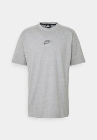 Šedé tričko s krátkým rukávem vyrobené z bavlny, s malým vícebarevným logem Nike vyšitým na hrudi, klasický design s kulatým výstřihem.
