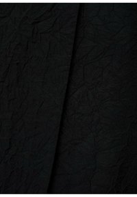 Tejido negro arrugado con una superficie texturizada, que presenta tonos variados de negro y sutiles pliegues, adecuado para diversas aplicaciones.