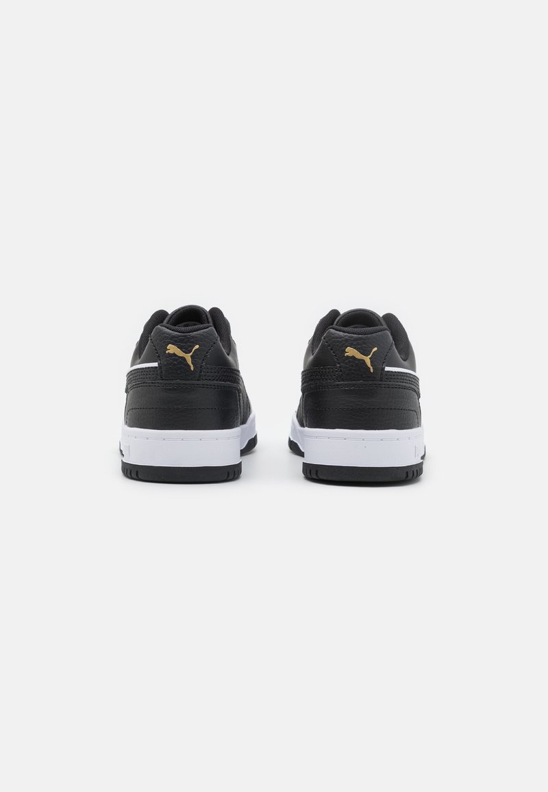Baskets noires avec une tige en cuir lisse, semelle intermédiaire blanche et semelle extérieure en caoutchouc noir. Accent logo doré sur le talon.