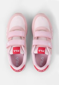 Zapatillas deportivas rosas con dos correas de Velcro. Parte superior sintética suave con detalles de malla. Acentos rojos y logo "FILA" en la lengüeta y el talón.