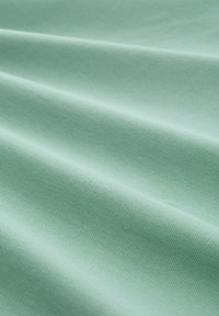Mintgrüner Textilstoff mit sichtbaren Falten und einer glatten Oberfläche, die ein einheitliches Webmuster zeigt. Ideal für verschiedene textile Anwendungen.