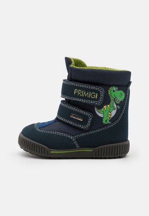 Botte enfant bleu foncé avec doublure verte, deux bandes Velcro, logo "Primigi" et un dinosaure vert de dessin animé sur le côté.