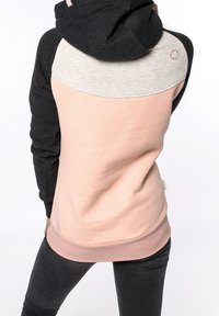 Sudadera con capucha que presenta paneles en negro, rosa claro y gris, con un corte relajado, textura suave y detalle de dobladillo acanalado.