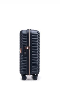 Valigia rigida con scanalature verticali, colore blu scuro, zip in rosa gold, serratura a combinazione e quattro ruote per la mobilità.