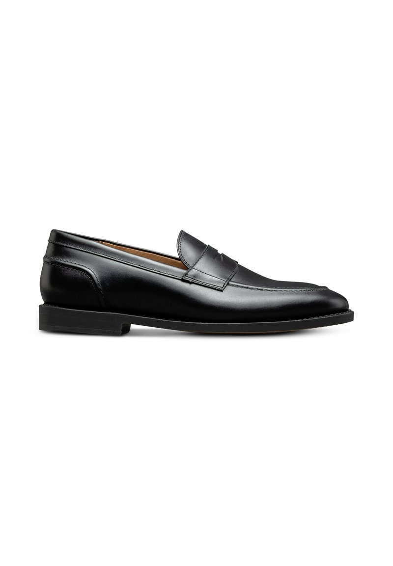 Mocassins en cuir noir avec une texture lisse, bout arrondi et un léger talon. Présente un accent cousu sur le dessus.
