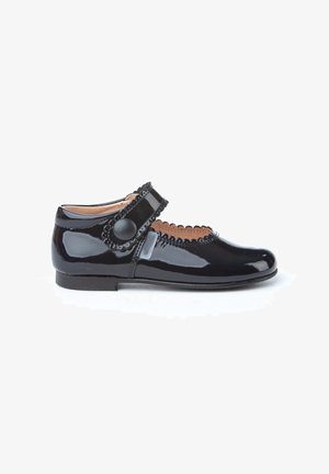 Zapato Mary Jane de charol negro con borde festoneado, correa ajustable y acento de botón redondo. Con tacón bajo y textura suave.