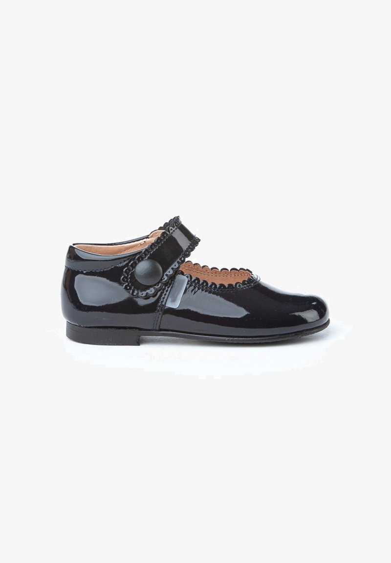 Zapato Mary Jane de charol negro con borde festoneado, correa ajustable y acento de botón redondo. Con tacón bajo y textura suave.