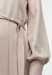 Φως μπεζ πλεκτό φόρεμα με σφιχτή μέση, διαθέτει ζώνη δέσιμου, μακριά μανίκια μπαλονιού και μαλακή υφή.