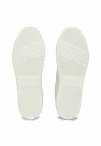 Semelles de baskets blanches avec des motifs de grip texturés, comportant un logo embossé sur le côté. Surface lisse dans l'ensemble avec des rainures subtiles.