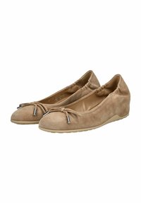 Ballerines en suède beige à talons compensés, avec bout rond, bord élastique et nœud orné de quincaillerie en métal argenté. Semelle douce avec grip texturé.