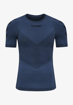 Marineblå sportsskjorte med korte ærmer, tekstureret chevronmønster, ribbede kanter, sorte pilmønstre på ærmerne og sort "hummel" logo på brystet.