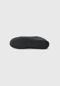 Talpa de sneaker neagră cu cauciuc texturat pentru aderență, având un model ondulat și logo. Formă rotunjită cu șanțuri de tracțiune definite.