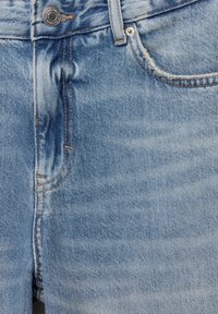 Jeans in denim azzurro chiaro con sezioni sbiadite, cuciture visibili e chiusura con bottone metallico in vita. Tasche standard senza motivi visibili.