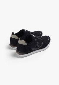 Tenisi negri cu un upper din țesătură texturată, accente gri, logo-ul cu skull distinctiv și o talpă din cauciuc alb cu toc maro.