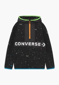 Czarna bluza z kapturem z gwiezdnym wzorem, pomarańczowym zamkiem i szarym logo "CONVERSE" na przodzie, z zielonymi akcentami na kapturze.