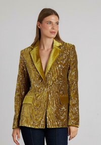 Metalen gouden en groene fluwelen blazer met een gemarmerd golfpatroon, notch-lapels, twee voorkeuzes en een getailleerde pasvorm.