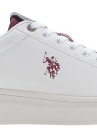 Valkoinen nahkakengät, joissa on pyöreä varvas, teksturoitu pohja ja burgundin sävyiset yksityiskohdat. Sivussa on viininpunainen polo-pelaajan logo.