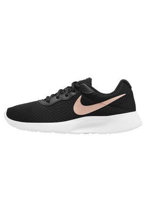 Sort snørebånd Nike løbesko med hvid sål og et lyserødt Nike swoosh-logo på siden, set fra ydersiden.