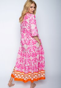 Rosa gemustertes Maxikleid mit Dreiviertelärmeln, gestuftem Rock und orangefarbener Borte, das ein florales Design und atmungsaktiven Stoff aufweist.