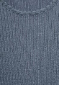 Hladký žebrovaný úplet v tmavě modré barvě, s kulatým výstřihem. Textura je hladká s vertikálními pruhy, což vytváří konzistentní vzor.