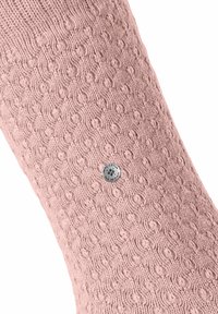 Chaussette rose tricotée avec un motif texturé et un accent logo circulaire argenté. Matériau doux, longueur mi-mollet et bord supérieur côtelé.