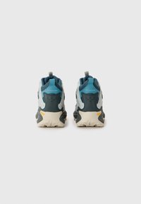 Sportowe sneakersy w ciemnozielonym i jasnoniebieskim kolorze, z teksturowanym wierzchem, wzmocnionym piętą oraz białą podeszwą z bieżnikami z logo Vibram.