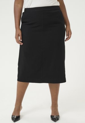 Jupe crayon noire de longueur genou avec une texture lisse, comportant des poches avant et une ceinture. Portez-la avec des ballerines noires à bout pointu.