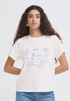 Femme portant un t-shirt blanc avec des dessins au trait bleus d'objets d'été et les textes « Mes essentiels d'été » et « Profitez de la vie. »