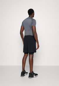 Athletic outfit featuring a fitted gray short-sleeve top and black shorts, paired with black athletic shoes. Simple design, breathable material.