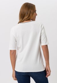Witte T-shirt met korte mouwen en een ronde hals, met een subtiele gestreepte accent op de kraag en een gladde, zachte textuur.