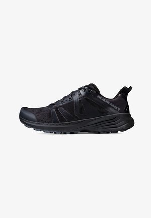 Chaussure de sport noire avec une tige en maille texturée, un renfort au niveau de l'embout, un système de laçage et un profil de semelle prononcé pour une meilleure adhérence. Présente le logo de la marque.