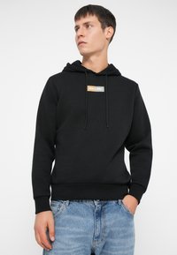 Felpa nera con cappuccio realizzata in tessuto morbido, caratterizzata da un piccolo logo ricamato in bianco e arancione sul petto; polsini e orlo a coste.