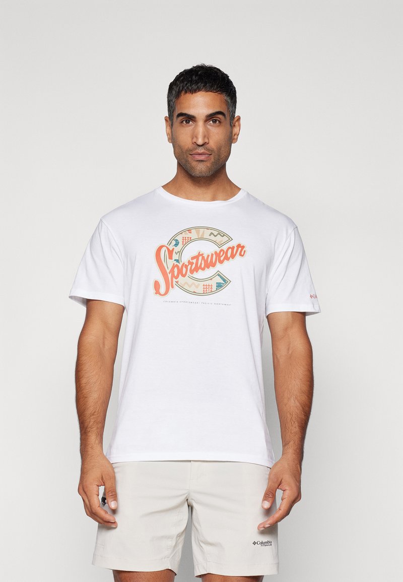 Hvit t-skjorte med korte ermer som har et flerfarget "Sportswear" grafisk design foran, glatt stoff, rund hals.