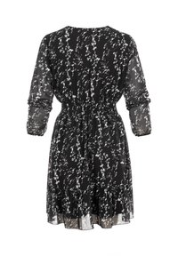 Robe noire à manches longues avec motif floral blanc, taille élastique, manches transparentes et ourlet à volants, vue de dos.