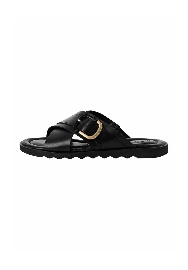 Black leather slide sandal featuring a cross-strap design, gold buckle detail, and a textured scalloped sole.