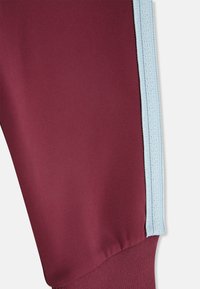 Pantaloni sportivi color bordeaux con strisce laterali azzurro chiaro. Tessuto liscio, design a gamba affusolata, vita elastica e polsini a coste.