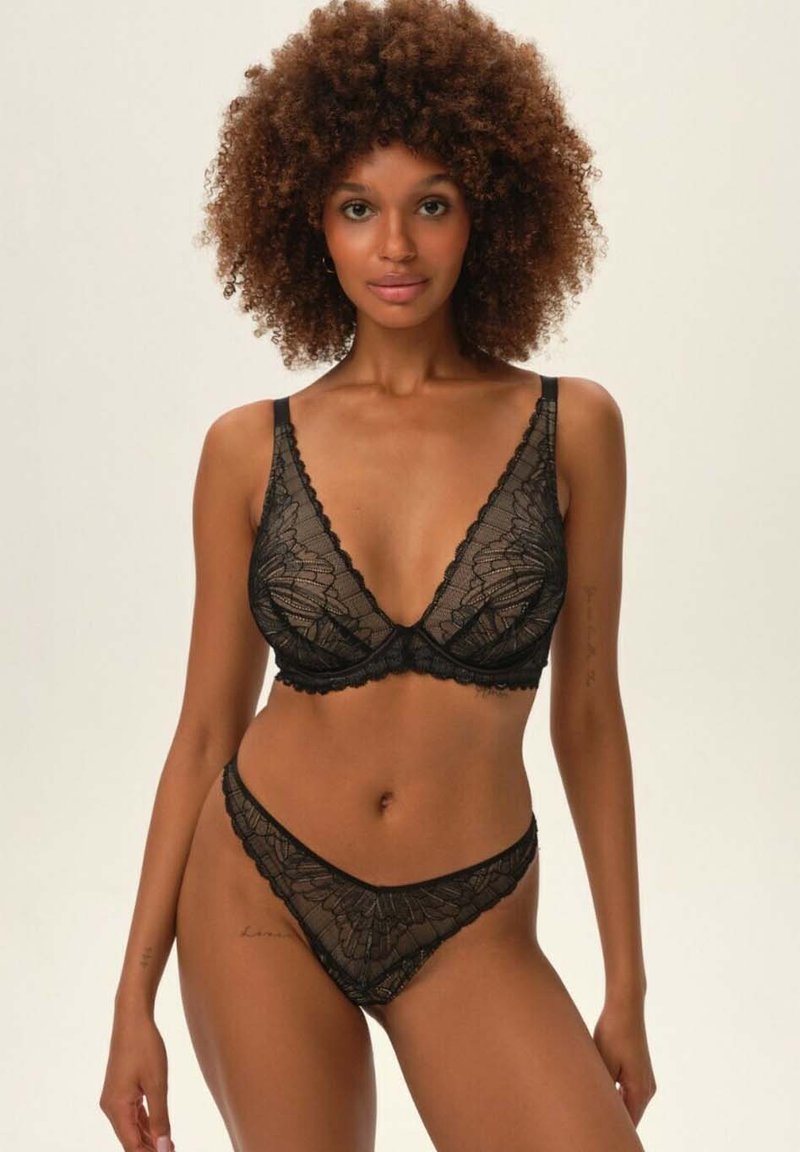 Czarny komplet koronkowej bielizny, składający się z trójkątnego biustonosza i pasujących stringów. Skomplikowane wzory kwiatowe, falbany na brzegach i miękka faktura.