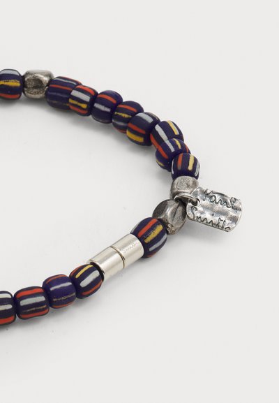 Bracelet en perles avec des perles cylindriques bleu marine, rouge, jaune et gris, doté d'un fermoir en métal argenté et d'une étiquette gravée.