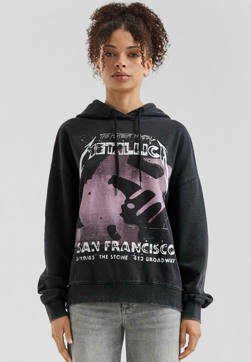 Czarna bluza z kapturem wykonana z bawełny, z grafiką z przodu zawierającą fioletowy wzór oraz tekst dotyczący koncertu Metallice w San Francisco w 2003 roku.